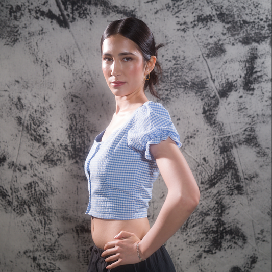 Side view of model in blue gingham puff-sleeve crop top