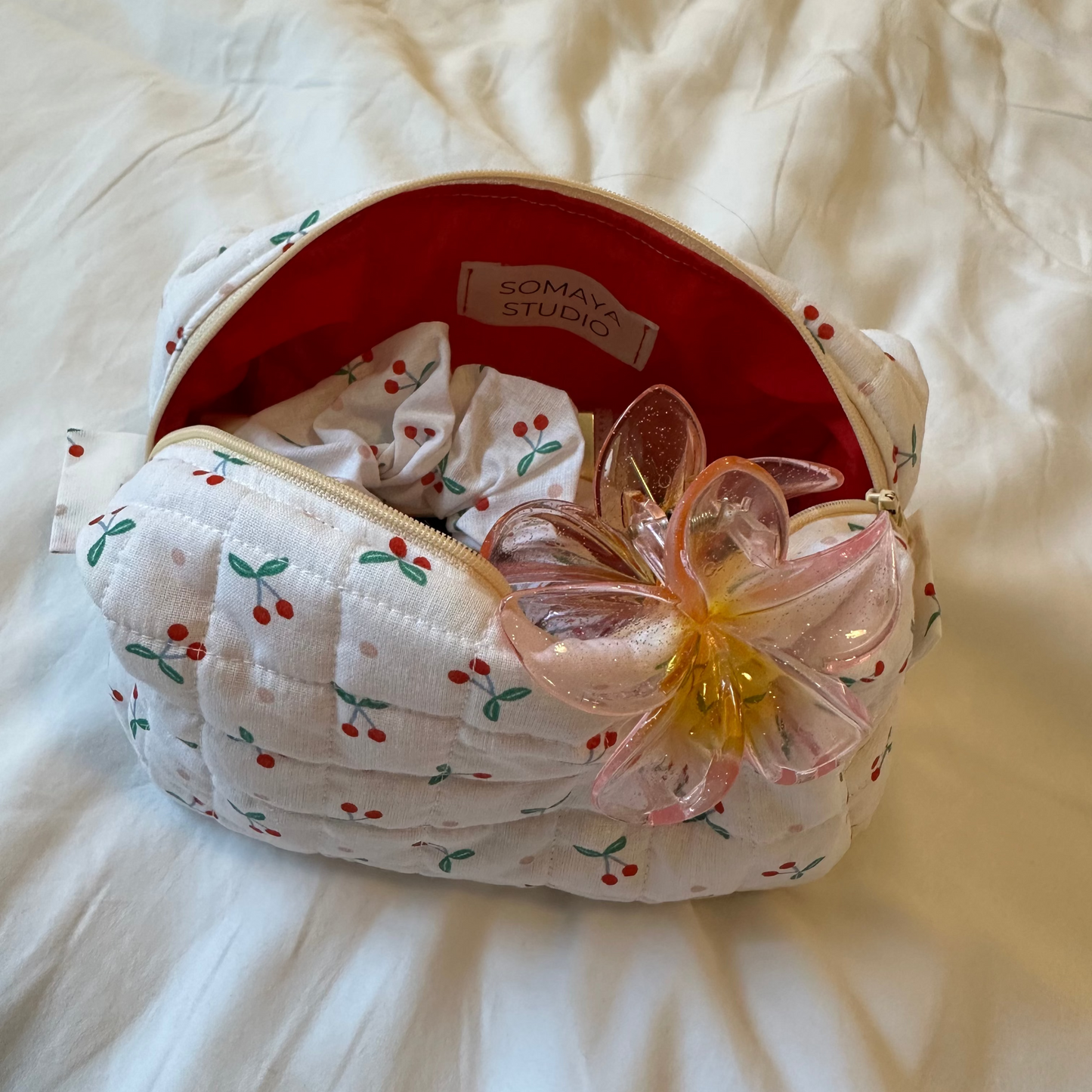 Top-down view of small cherry pouches opened to reveal vibrant red lining and roomy interior.