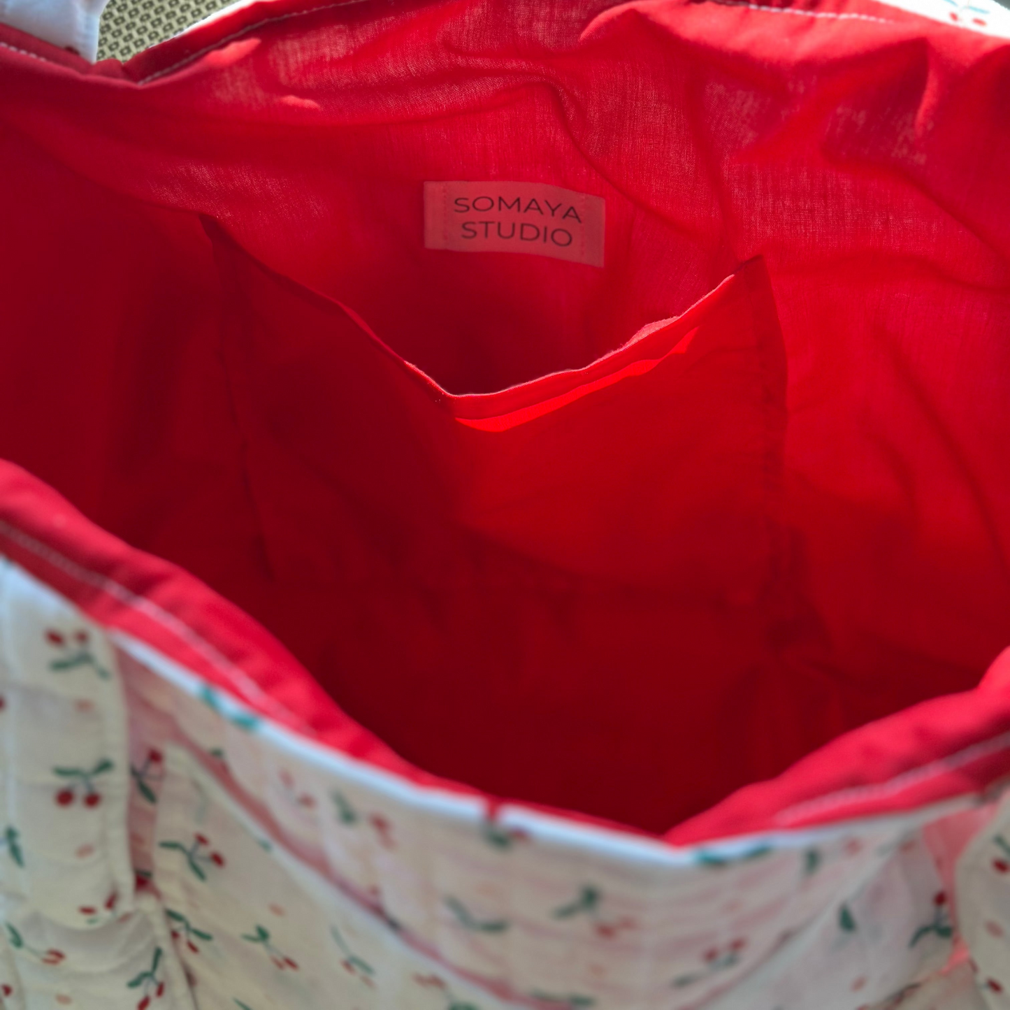Inside view of tote bag showing red lining and pocket