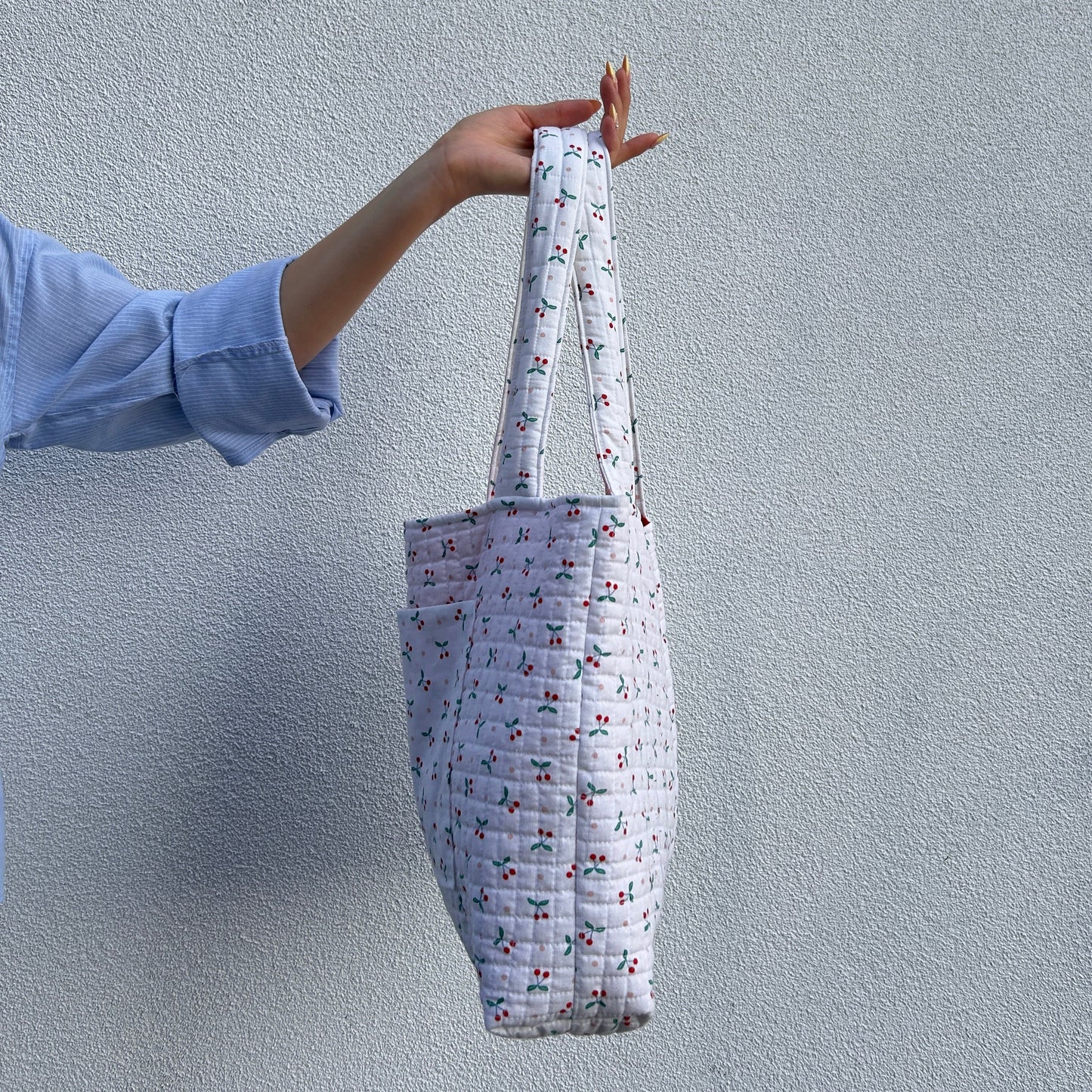 Side profile of soft quilted tote bag in cherry fabric