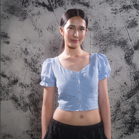 Woman wearing blue gingham crop top, front view with smile