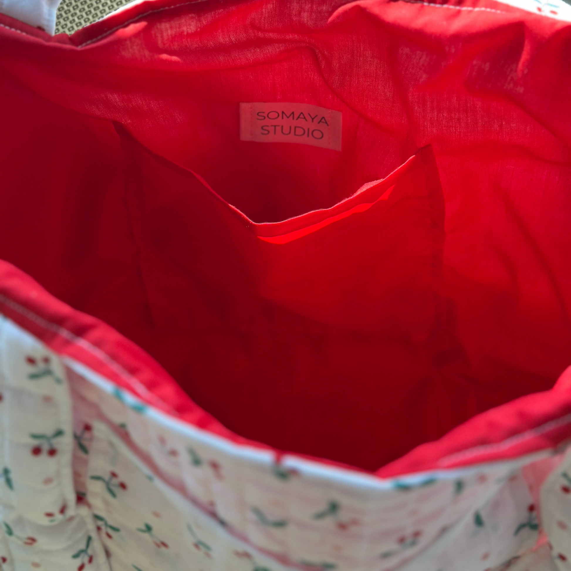 Inside view of tote bag showing red lining and pocket
